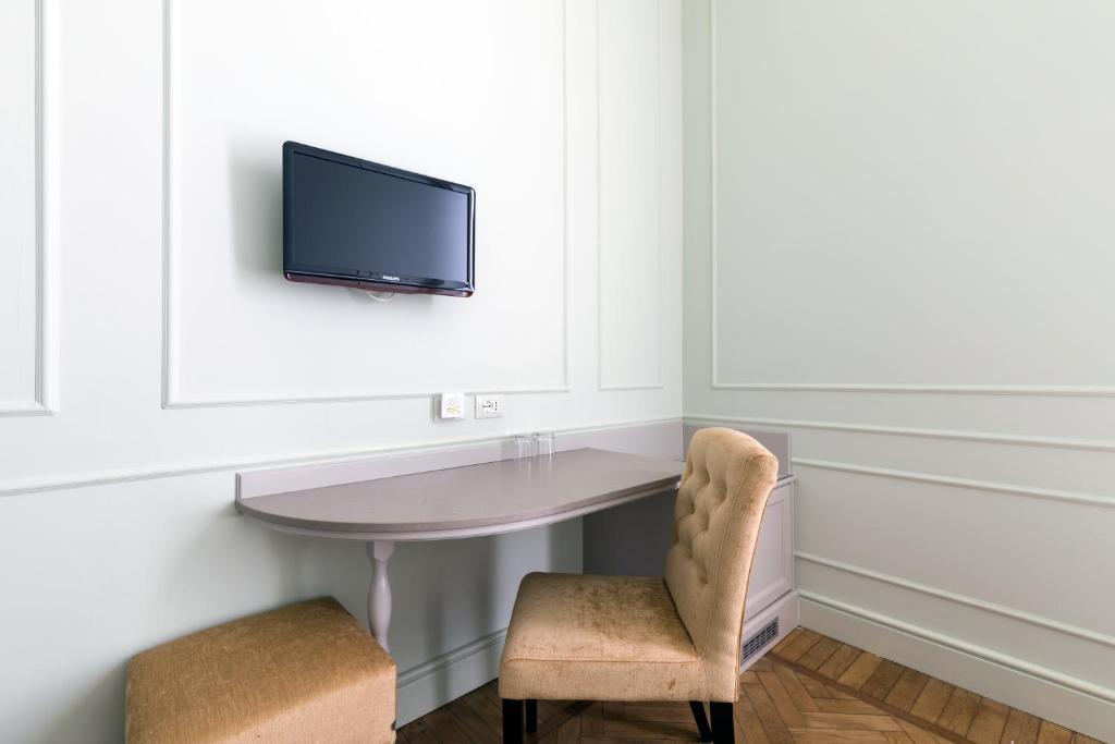 une pièce avec une table et deux chaises et une télévision dans l'établissement Hotel Eden Alaxi Hotels, à Alassio