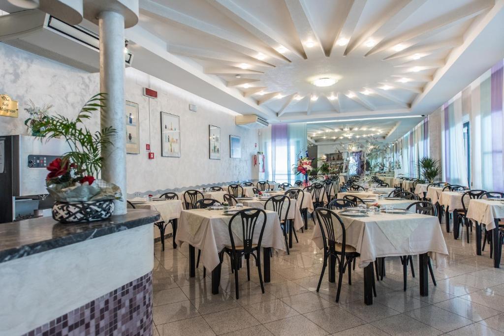un restaurant avec des tables et des chaises dans une salle dans l'établissement Hotel Nuovo Giardino, à Rimini