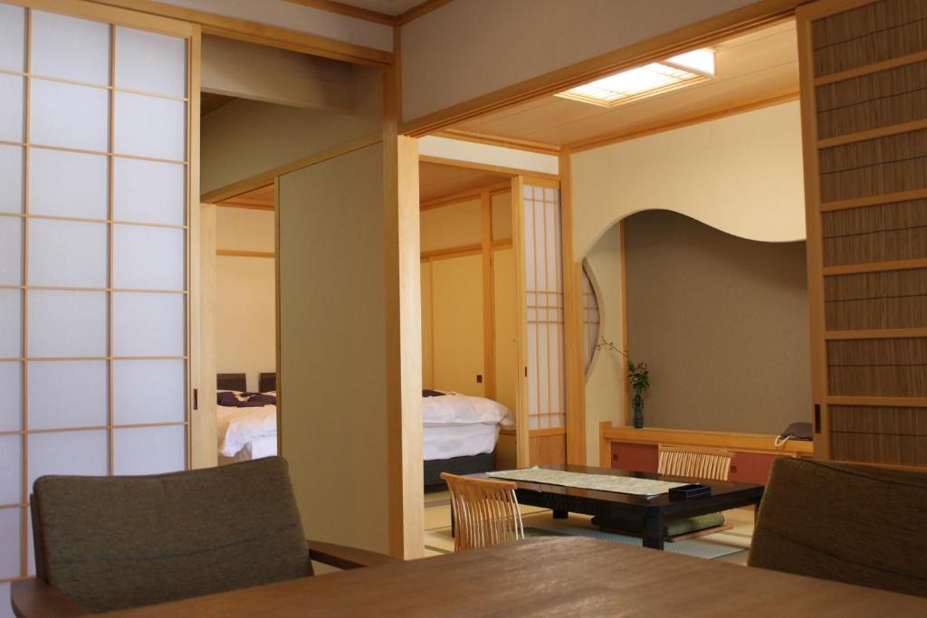 une chambre avec une table et une chambre avec une chambre dans l'établissement Hanaichi, à Tsumagoi