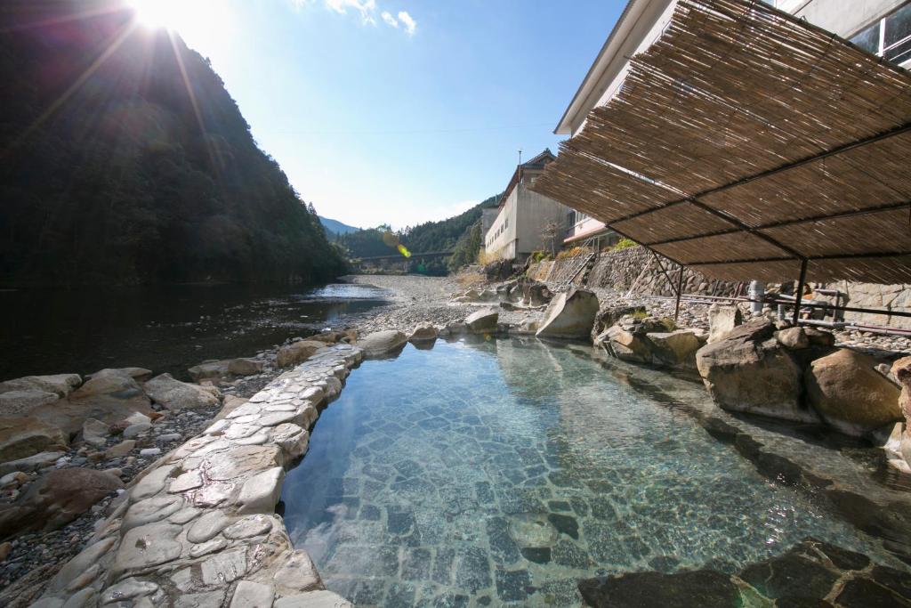 un bassin d'eau à côté d'une rivière dans l'établissement Sansuikan Kawayu Matsuya, à Hongu