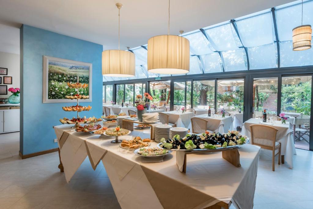 une salle à manger avec une longue table remplie de nourriture dans l'établissement Hotel Andreaneri, à Marina di Pietrasanta