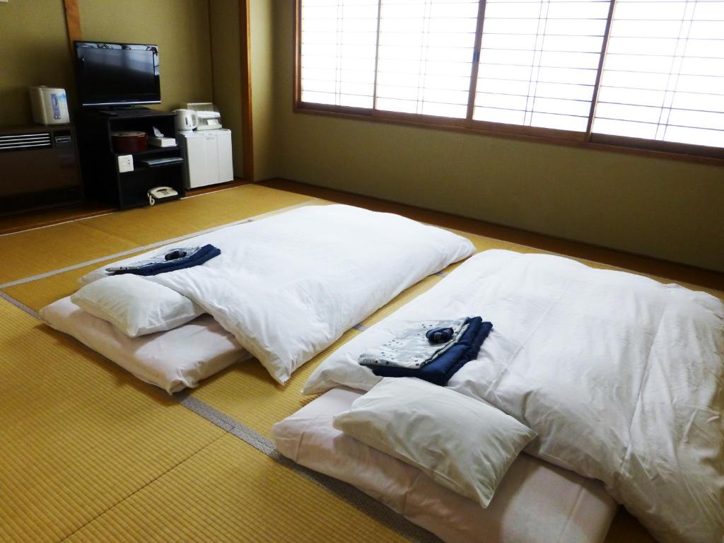 Cette chambre comprend 3 oreillers blancs au sol. dans l'établissement Kawaguchiko Lakeside Hotel, à Fujikawaguchiko 37 autres photos