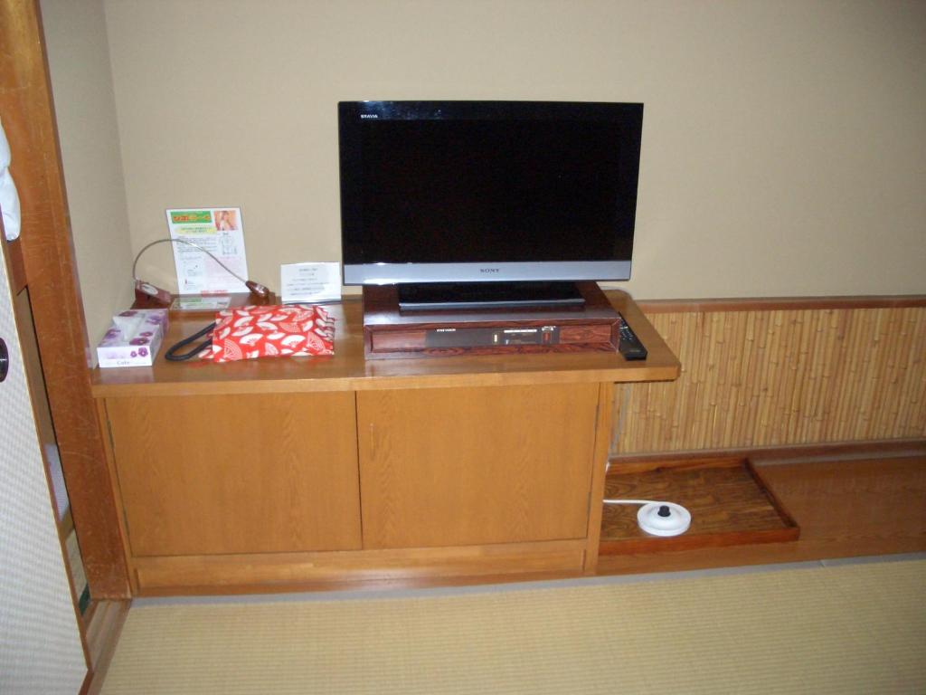 un téléviseur sur un meuble dans une pièce dans l'établissement Hotel Yamadaya, à Shimoda
