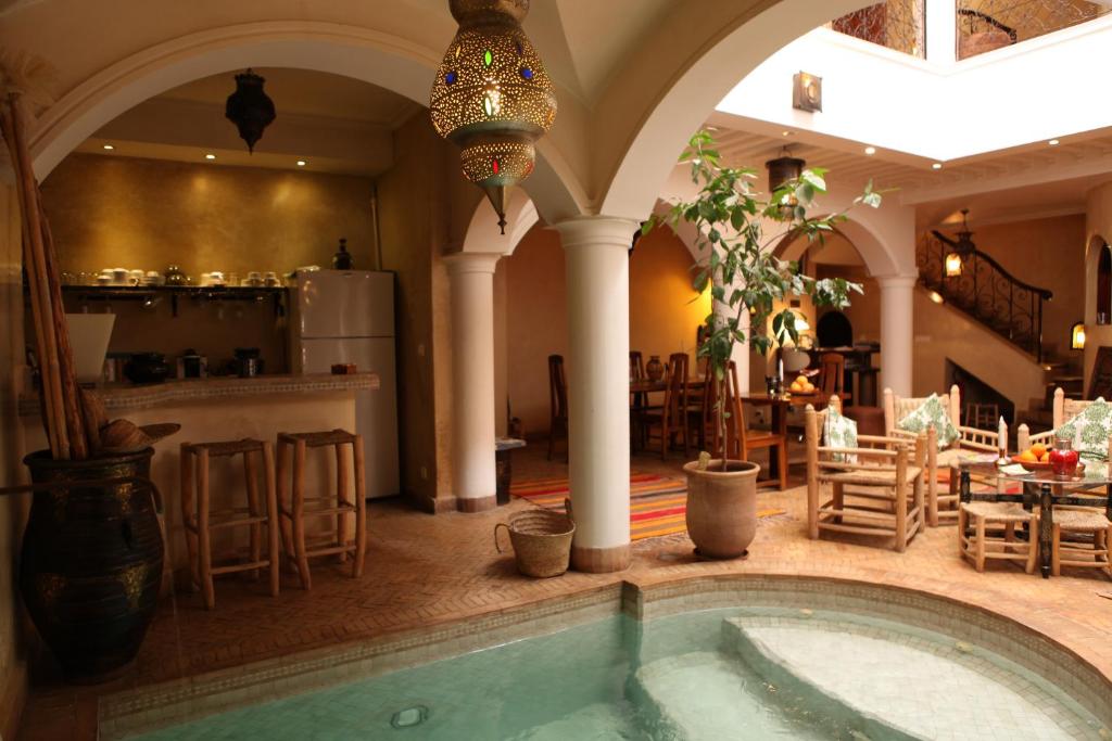 une grande chambre avec une piscine dans une maison dans l'établissement Riad L'Emir, à Marrakech