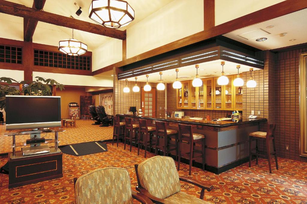 un hall d'entrée avec un bar avec des chaises et une télévision dans l'établissement Watarase Onsen Hotel Sasayuri, à Hongu
