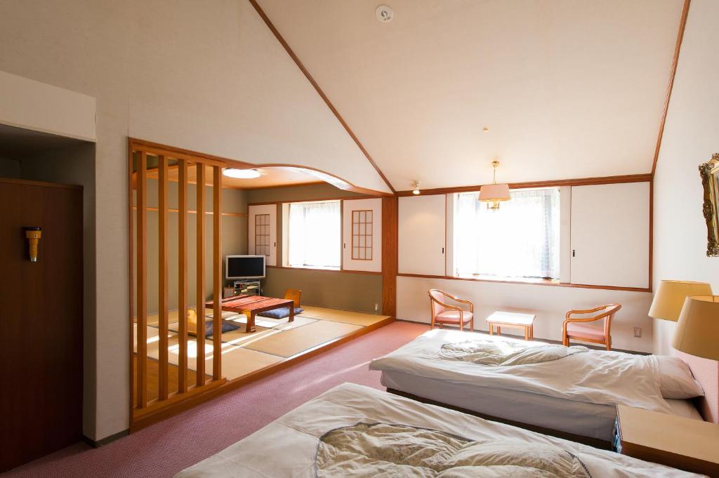 une chambre avec deux lits et un salon dans l'établissement Watarase Onsen Hotel Sasayuri, à Hongu