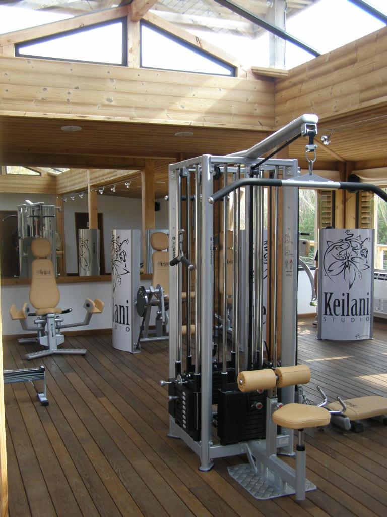une salle de sport avec plusieurs tapis de course et machines dans l'établissement Vic's Land Holidays, à Grimaud