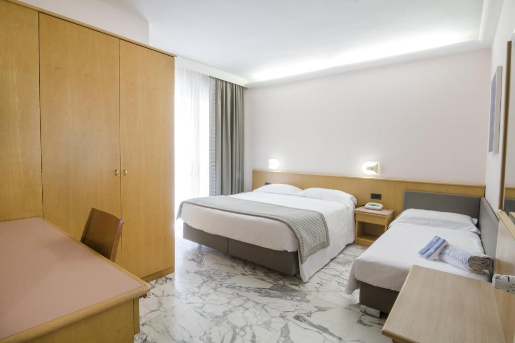 une chambre d'hôtel avec deux lits et une table dans l'établissement Hotel Mistral, à Termoli 34 autres photos