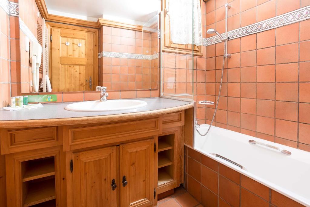 une salle de bain avec un lavabo et une baignoire dans l'établissement Les Balcons du Savoy 104 appt - Chamonix All Year, à Chamonix-Mont-Blanc 28 autres photos