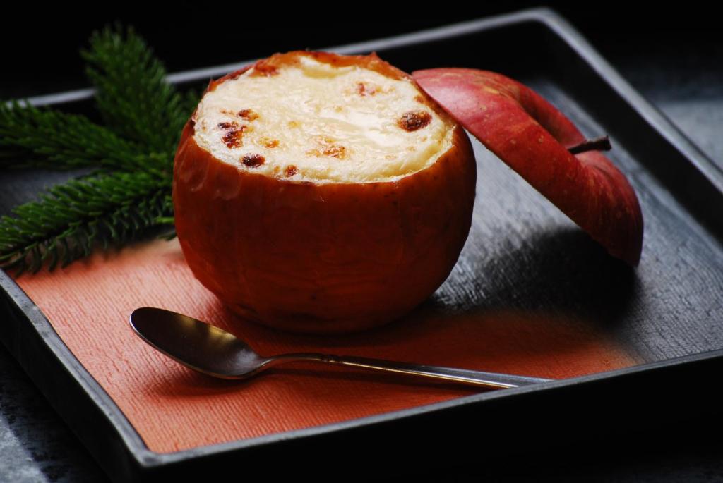 une pomme assise sur une assiette avec une cuillère dans l'établissement Oribana, à Omachi