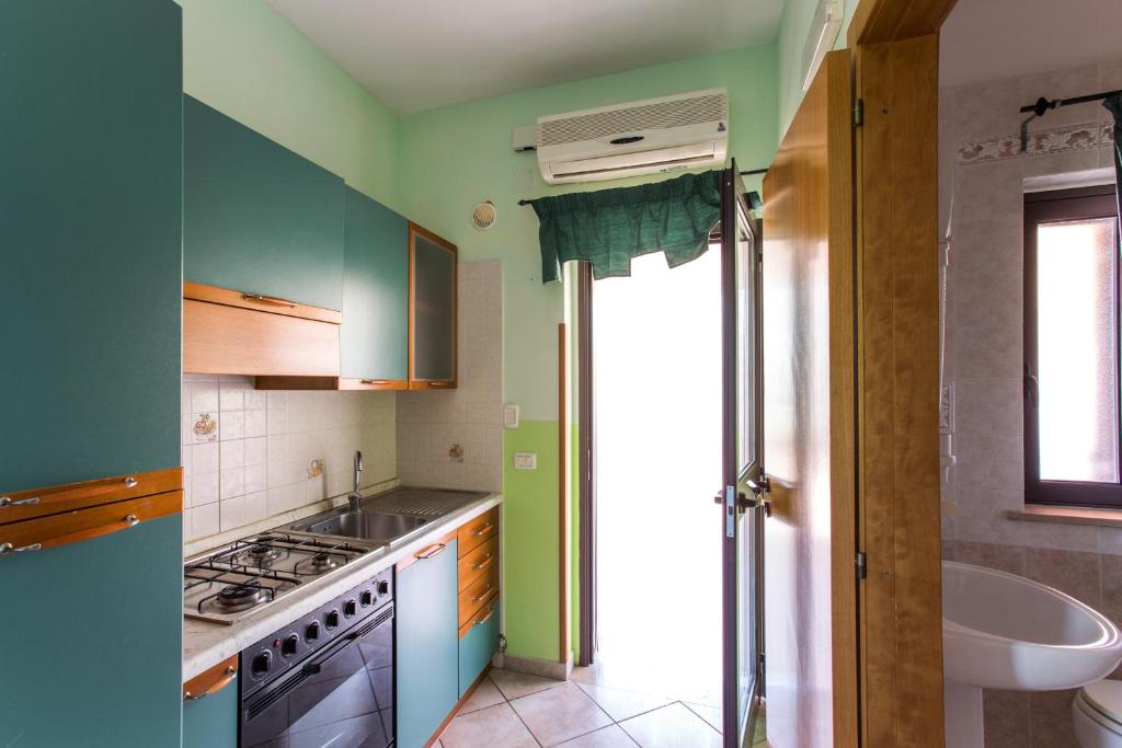 - une cuisine avec des murs bleus et verts et un évier dans l'établissement Tenuta Padre Pio, à Vieste