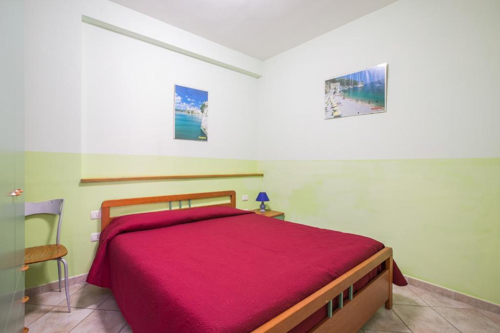 une chambre avec un lit avec une couverture rouge dans l'établissement Tenuta Padre Pio, à Vieste 108 autres photos