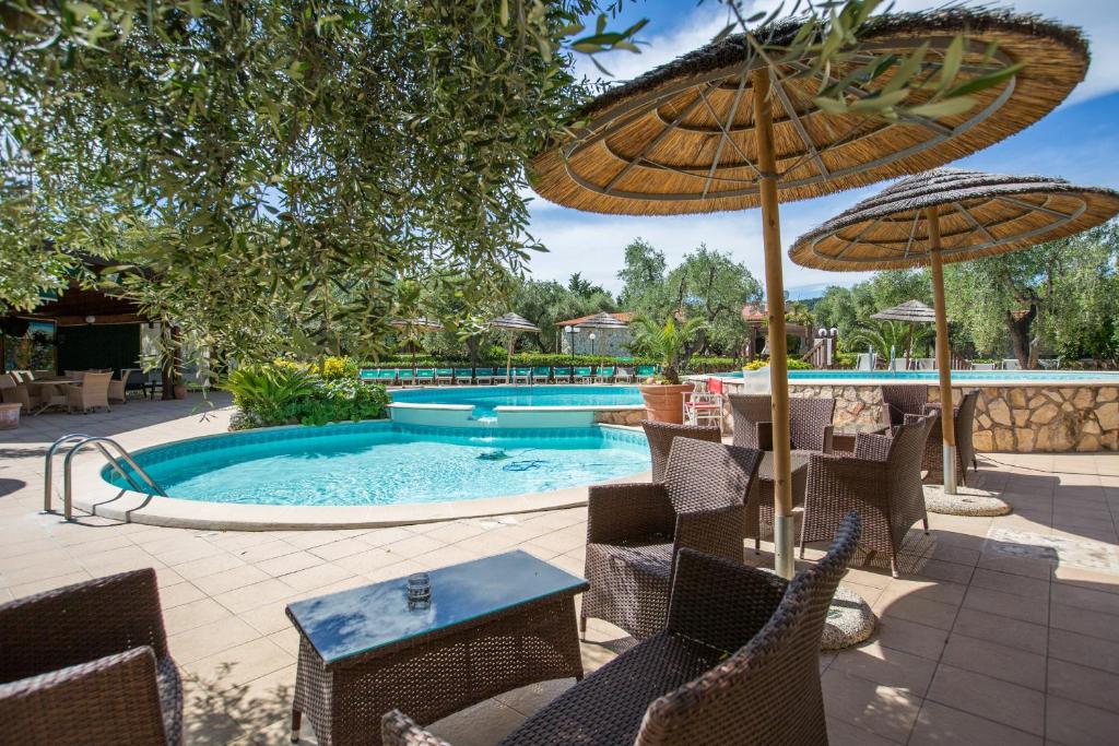une piscine avec chaises et parasols et une piscine dans l'établissement Tenuta Padre Pio, à Vieste