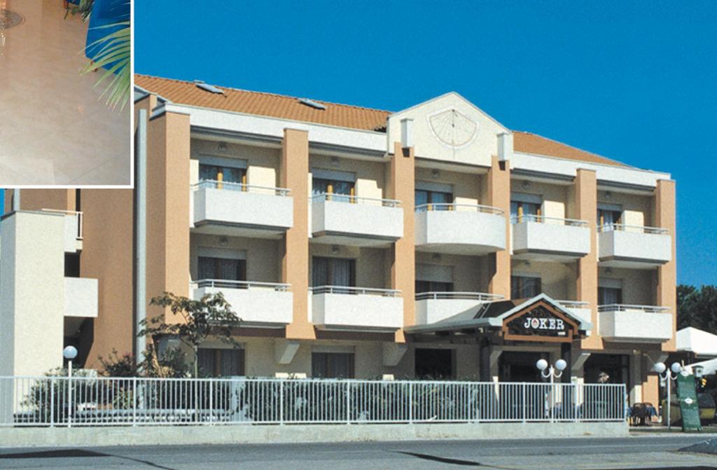 un grand bâtiment avec une horloge en haut dans l'établissement Residence Joker, à Cavallino-Treporti