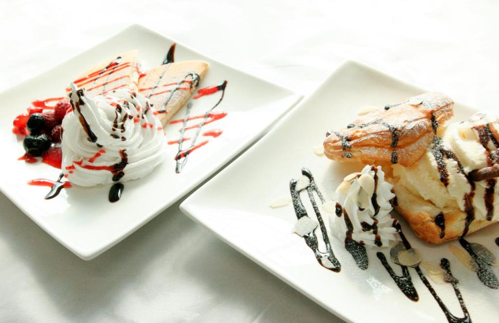 - deux assiettes blanches avec des desserts sur une table dans l'établissement Hotel NOA (Adult Only), à Anjomachi