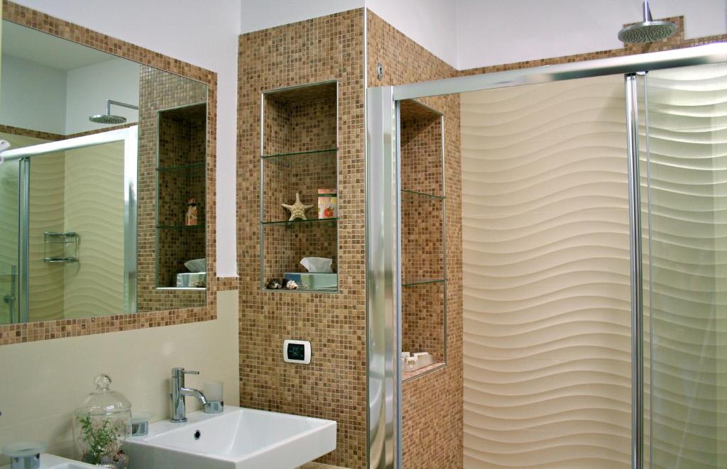 une salle de bain avec douche et lavabo dans l'établissement Hotel I Ginepri, à Marina di Castagneto Carducci