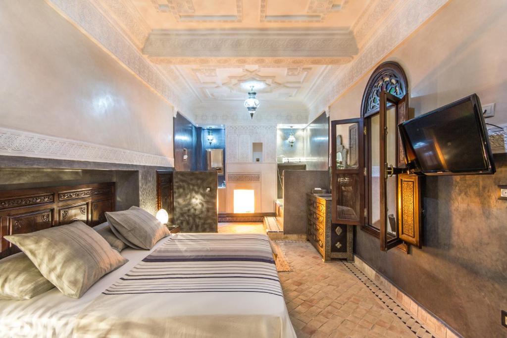 une chambre avec deux lits et une télévision à écran plat dans l'établissement Riad Lamya Marrakech, à Marrakech