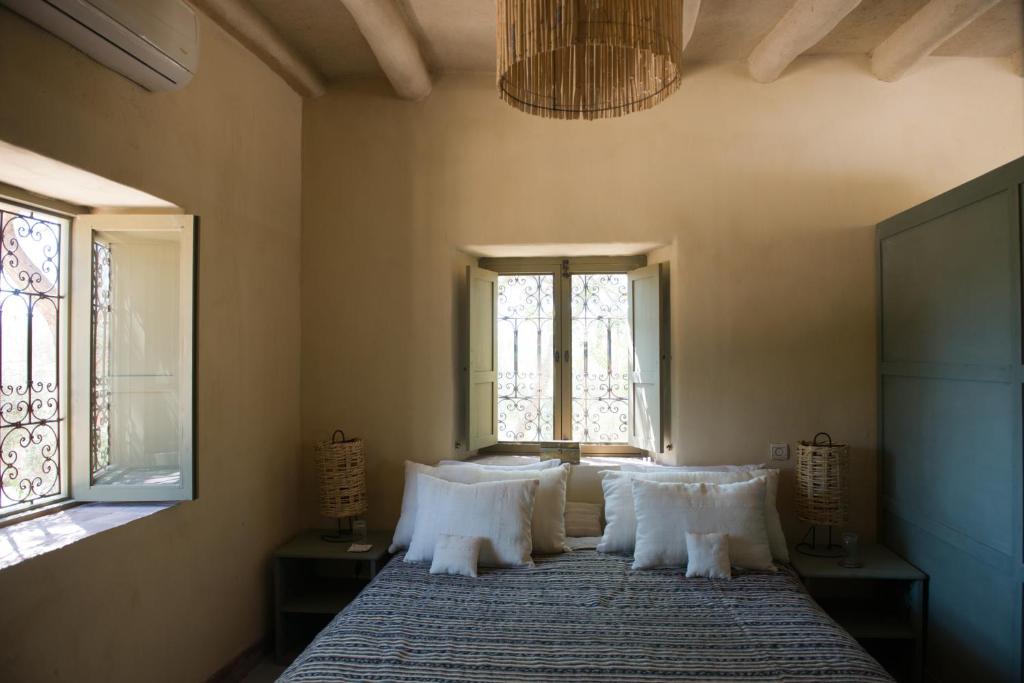 une chambre avec un lit avec des oreillers et une fenêtre dans l'établissement Dar al Hossoun, à Taroudant