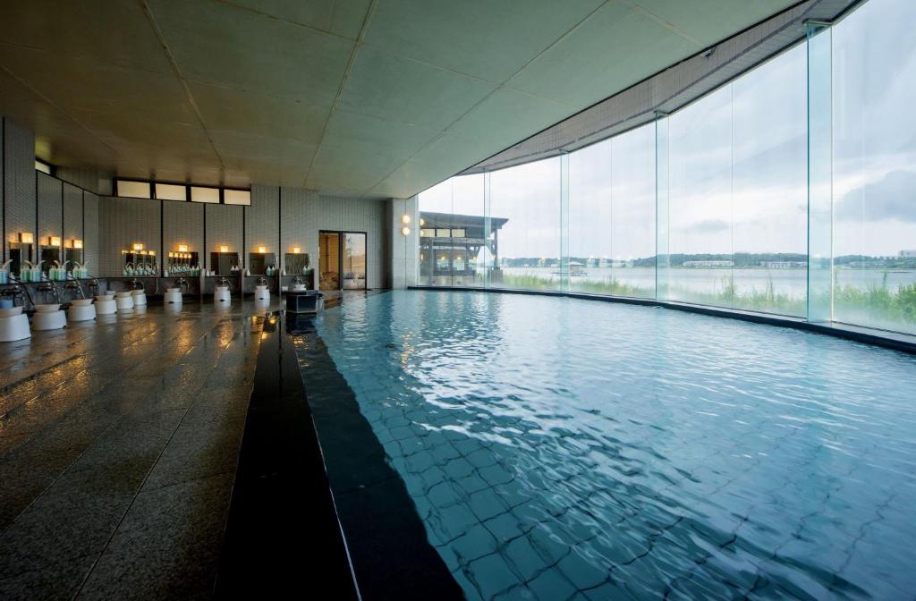 une grande piscine dans un immeuble avec une grande fenêtre dans l'établissement Kohan-no-Yado Morimoto, à Kaga