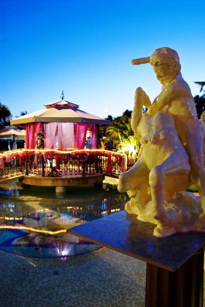une statue d'un homme assis au sommet d'une fontaine dans l'établissement Afrodite Boutique Hotel, à Bovalino Marina