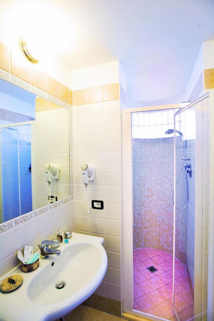 une salle de bain avec un lavabo et une douche dans l'établissement Hotel Etna - Hotel per Coppie e Famiglie con Parcheggio e Spiaggia, à Riccione