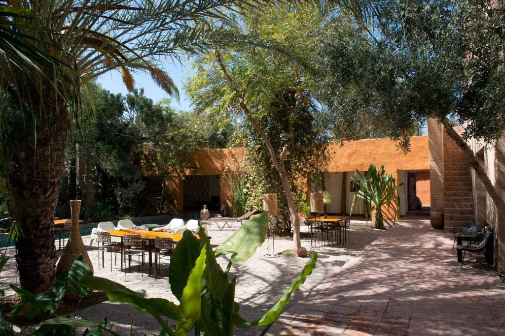 une cour avec des tables, des chaises et des arbres dans l'établissement Dar al Hossoun, à Taroudant