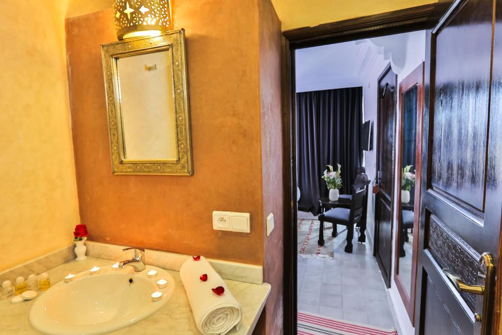 une salle de bain avec un lavabo et un miroir dans l'établissement Riad Diamant Blanc, à Essaouira