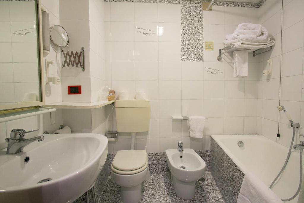 une salle de bain avec un lavabo, des toilettes et une baignoire dans l'établissement Hotel Salsello, à Bisceglie
