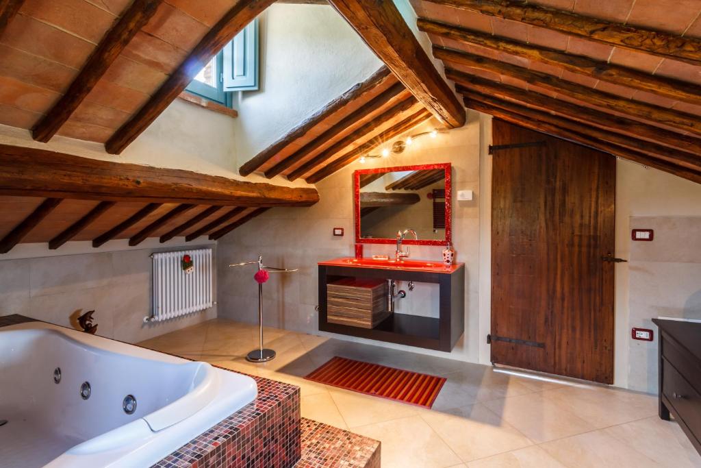 La grande salle de bains est pourvue d'une baignoire et d'un miroir. dans l'établissement Villa Teresa, à Cortone