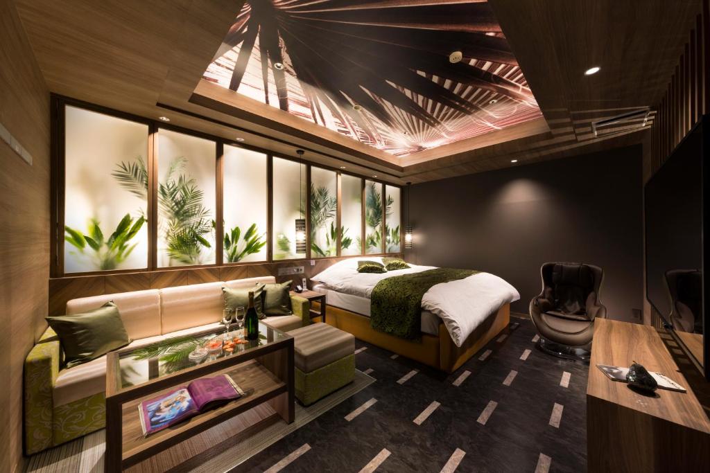 une chambre avec un lit, un bureau et une chaise dans l'établissement Hotel Plant Garden Resort (Adult Only), à Toyokawa