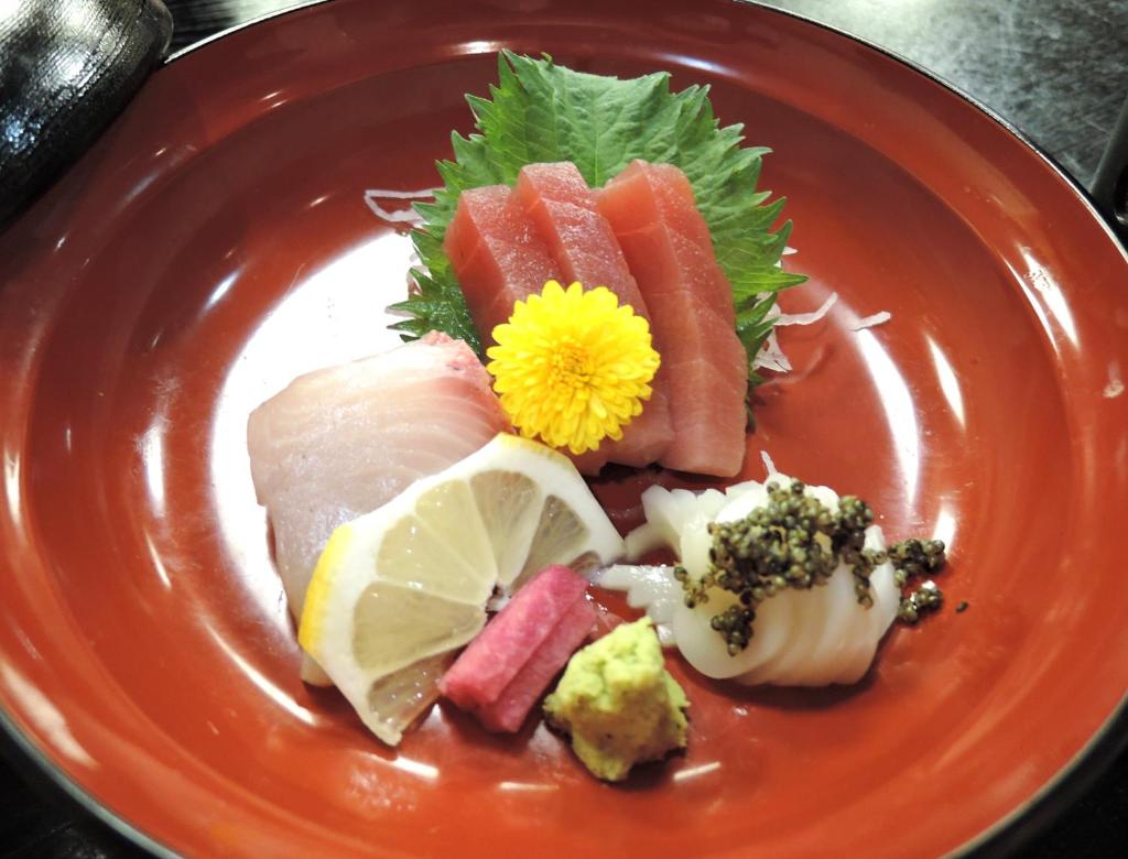 - une assiette de nourriture avec des sushis et des légumes dans l'établissement Nishiki Onsen Kurion, à Senboku