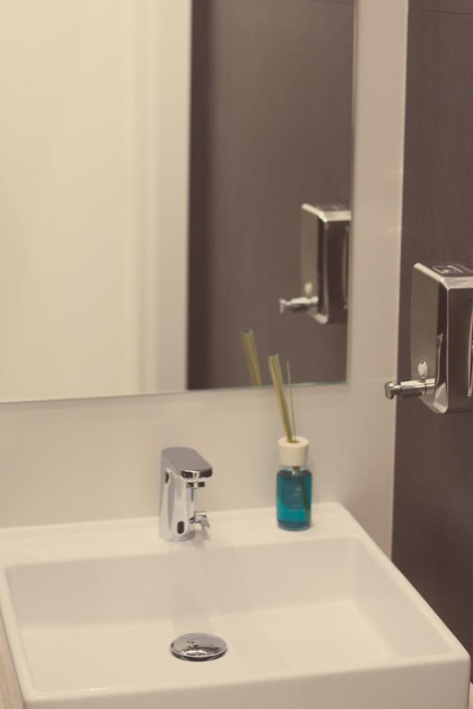 une salle de bain avec un lavabo et un miroir dans l'établissement Hotel Ristorante Rinelli, à Margherita di Savoia 89 autres photos