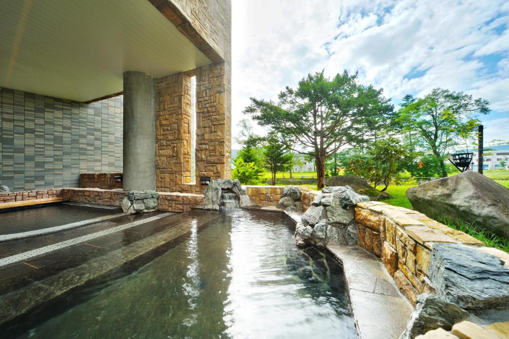 une piscine d'eau en face d'un bâtiment dans l'établissement Oehonke, à Kitami