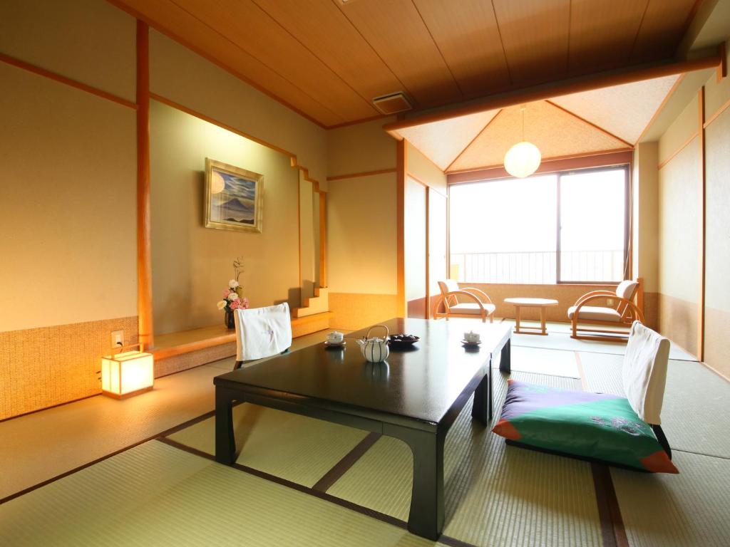 un salon avec une table et des chaises noires dans l'établissement Kasuitei Ooya, à Fujikawaguchiko