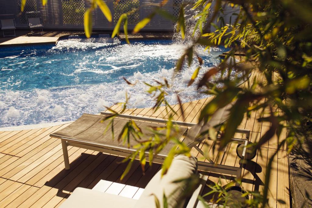 une piscine avec une terrasse en bois et un banc dans l'eau dans l'établissement Hotel Saraceno Resort with Private Beach, à Milano Marittima 146 autres photos