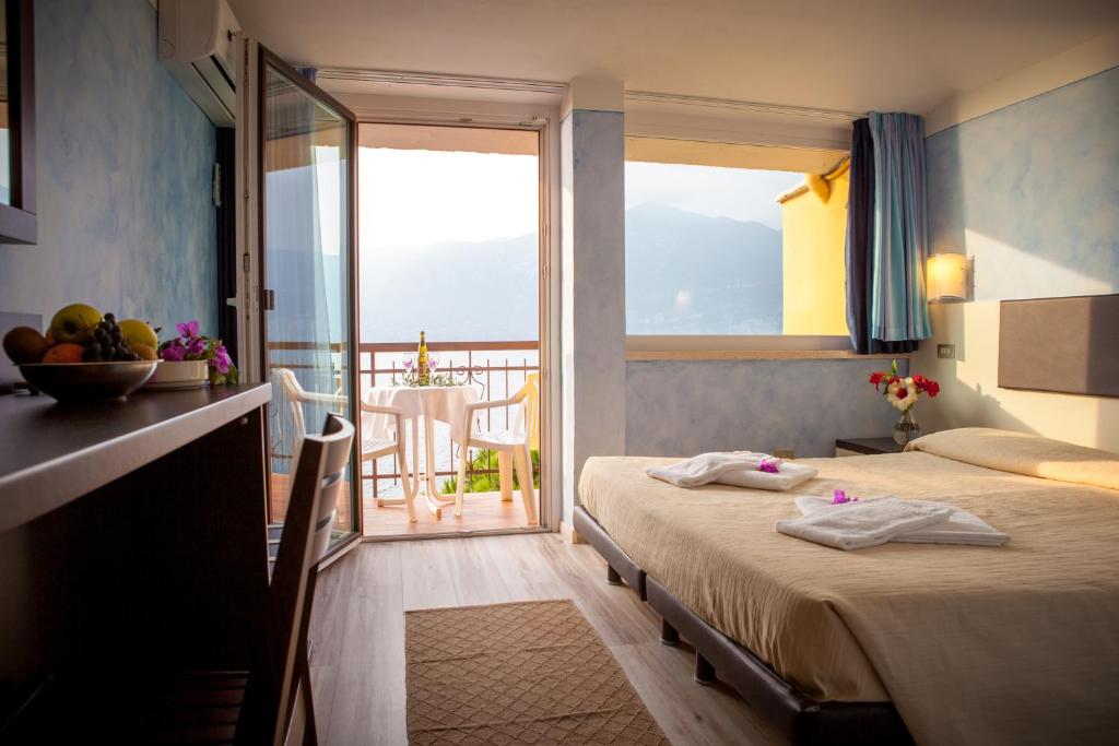 une chambre d'hôtel avec deux lits et un balcon dans l'établissement Taki Village, à Brenzone