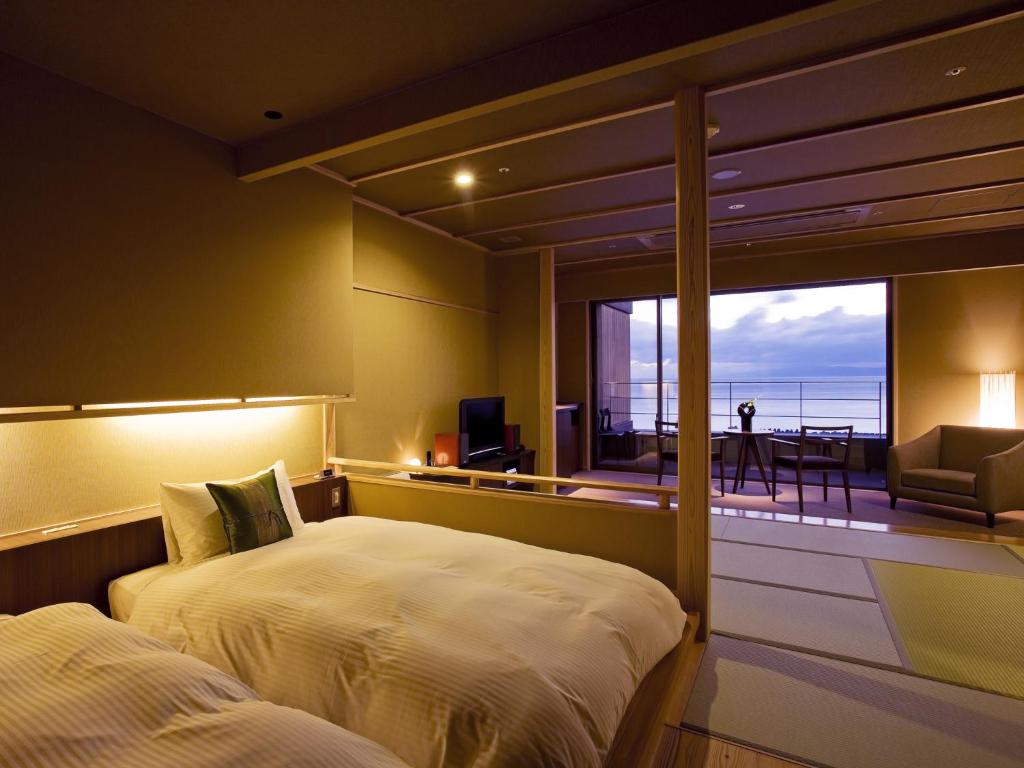 une chambre avec un lit et un balcon avec vue dans l'établissement Amahara, à Sumoto 36 autres photos