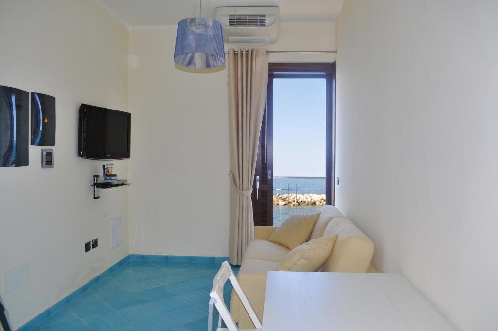 un salon avec un canapé et une fenêtre dans l'établissement Residence Tre Palme, à Acciaroli