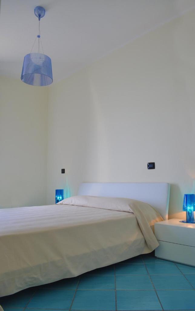Ce lit se trouve dans un dortoir doté de 2 lampes bleues. dans l'établissement Residence Tre Palme, à Acciaroli