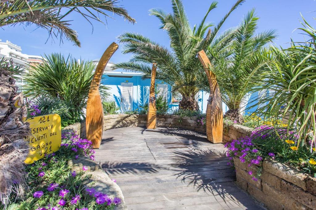une allée avec des palmiers et des fleurs dans un complexe hôtelier dans l'établissement Hotel Nuovo Giardino, à Rimini