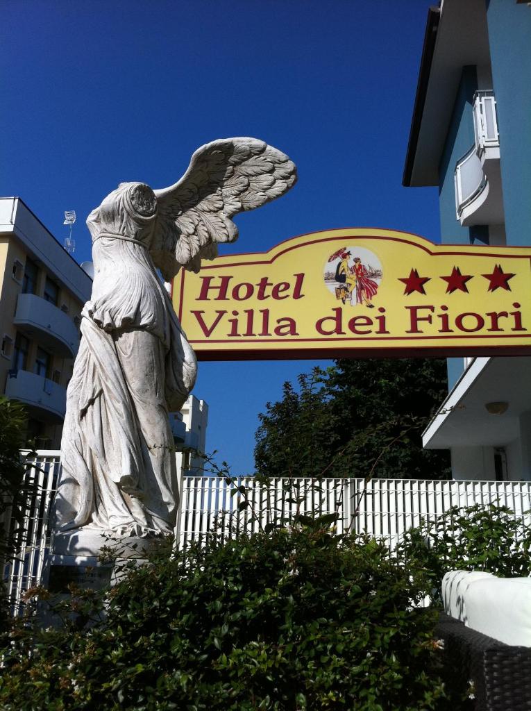 une statue d'un ange debout devant une hôtelilla del front dans l'établissement Hotel Villa dei Fiori - sul mare con piscina, à Rimini