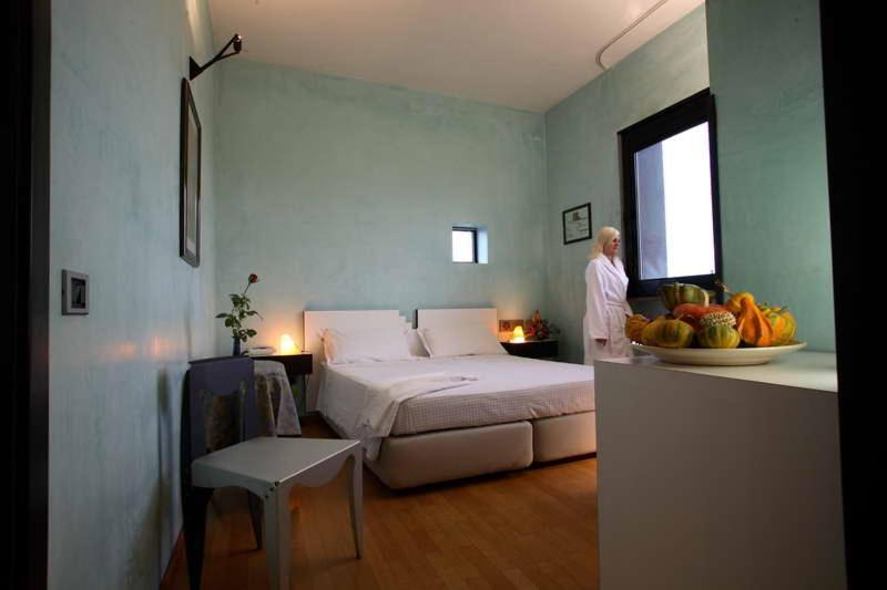 - un homme debout dans une chambre avec un lit et un bol de fruits dans l'établissement L'Angolo Di Beppe, à Torre Lapillo 61 autres photos