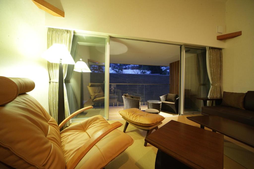 un salon avec un canapé et une table dans l'établissement Four Seasons Yuzawa Quattro, à Yuzawa