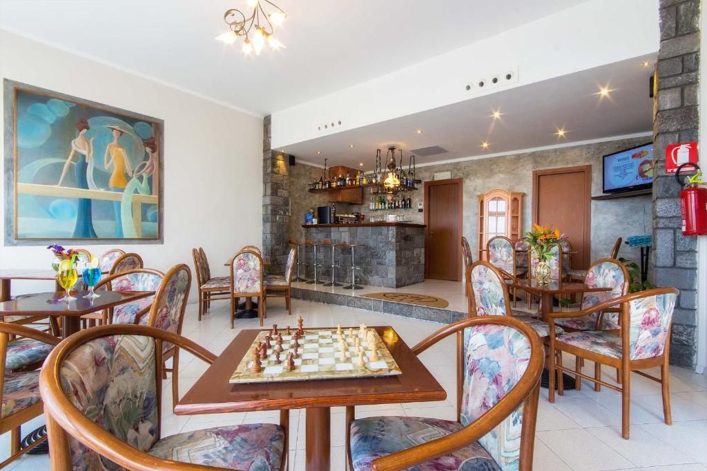 une salle à manger avec un échiquier sur une table dans l'établissement Piccolo Hotel, à Diano Marina