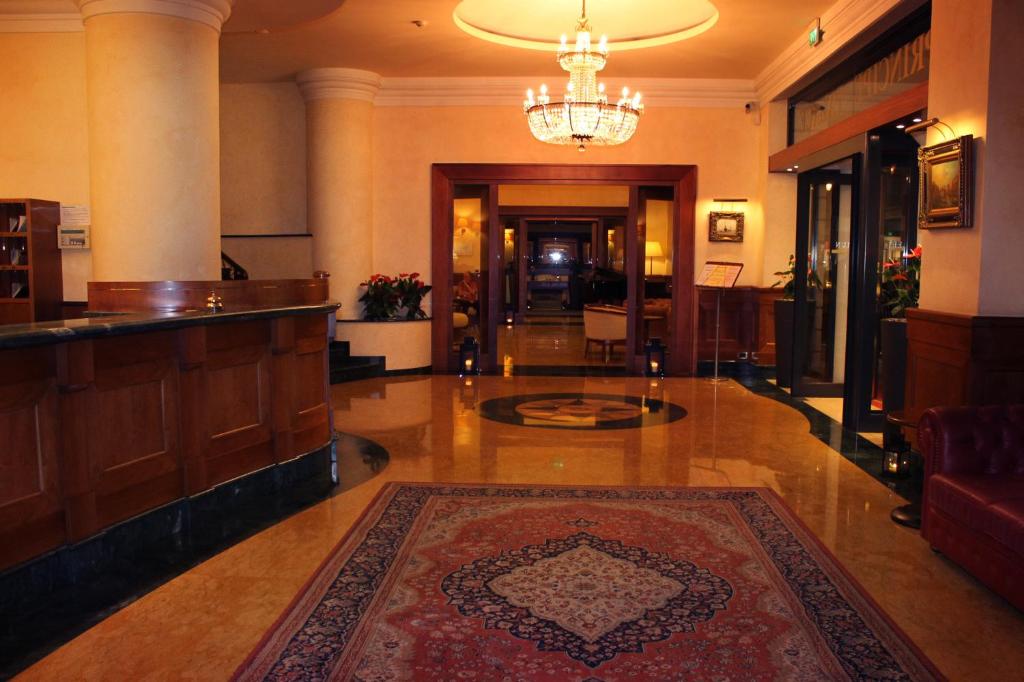 un hall d'entrée avec un tapis au sol et un lustre dans l'établissement Hotel Principe Palace, à Lido di Jesolo 32 autres photos
