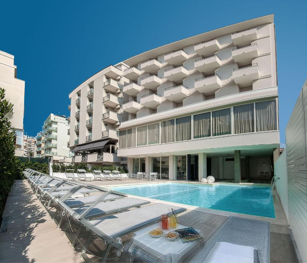 une piscine devant un bâtiment dans l'établissement Hotel Niagara, à Cattolica