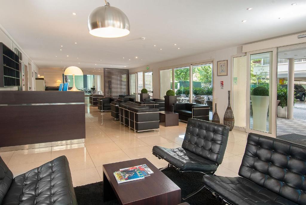 - un hall avec des fauteuils en cuir noir et une salle d'attente dans l'établissement Hotel Niagara, à Cattolica