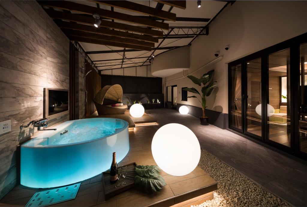 La salle de bains est pourvue d'une grande baignoire au milieu. dans l'établissement Hotel Plant Garden Resort (Adult Only), à Toyokawa