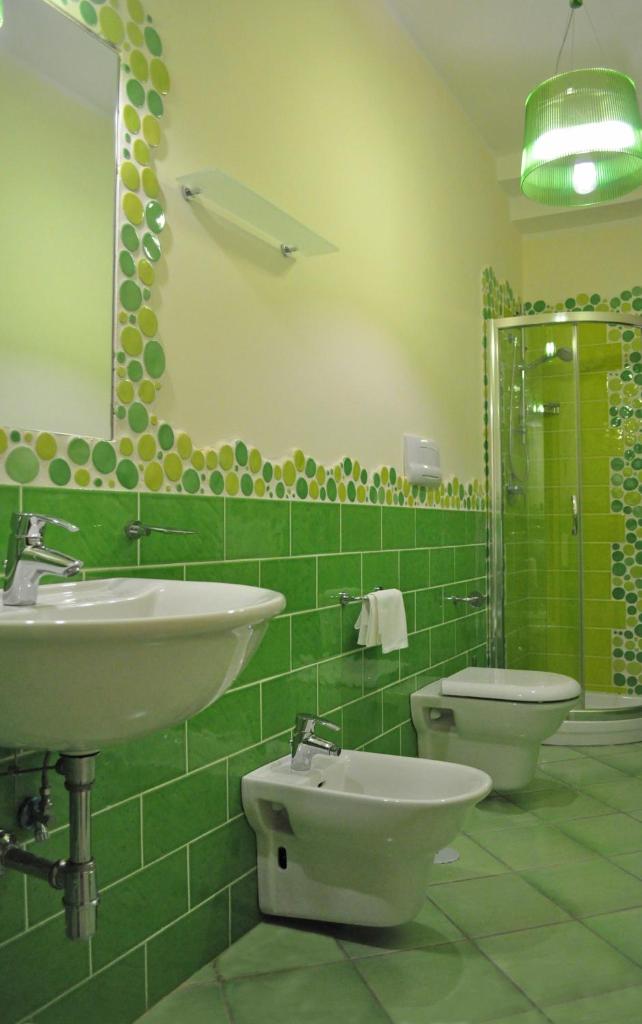 une salle de bain carrelée verte avec un lavabo et des toilettes dans l'établissement Residence Tre Palme, à Acciaroli