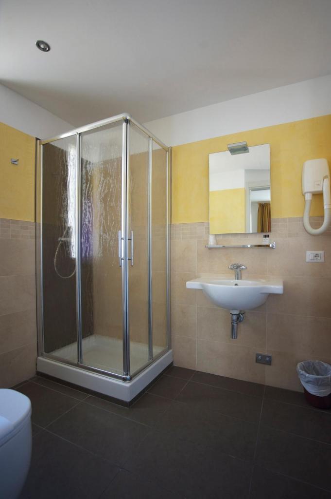 une salle de bain avec douche et lavabo dans l'établissement Hotel Stella Marina, à San Vincenzo